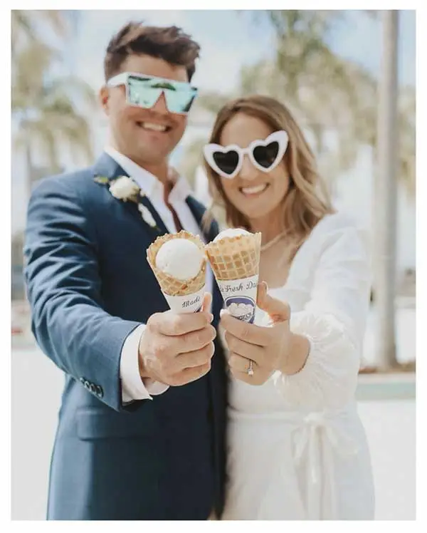 bride and groom eating ice cream on the beach