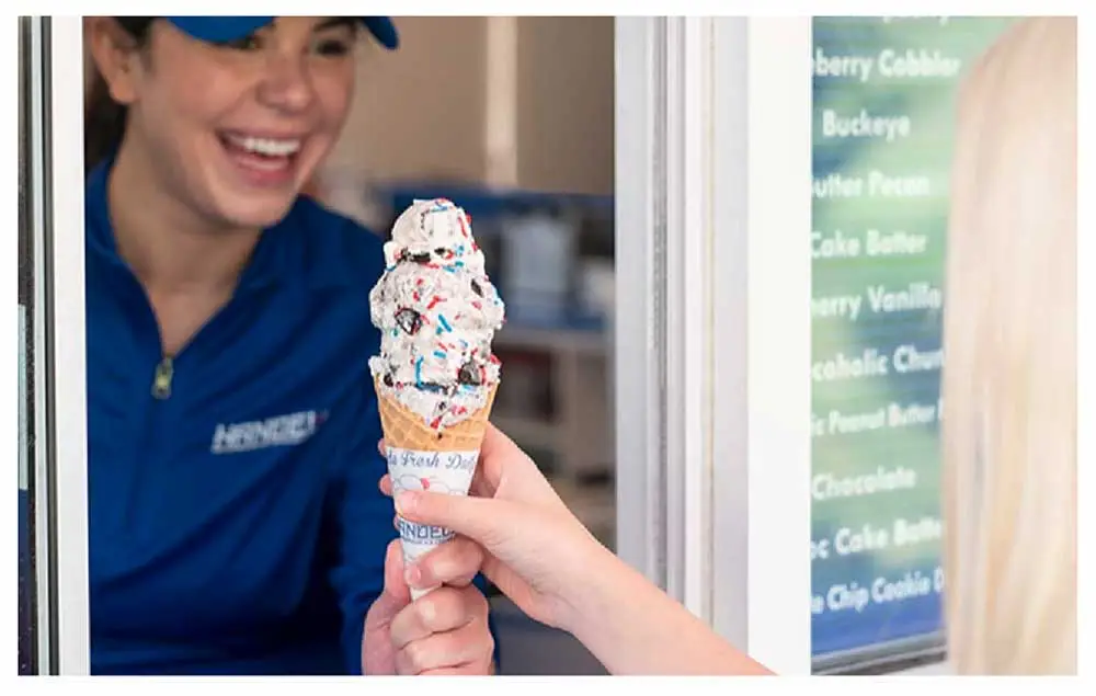 Handel's server handing an ice cream cone to a customer
