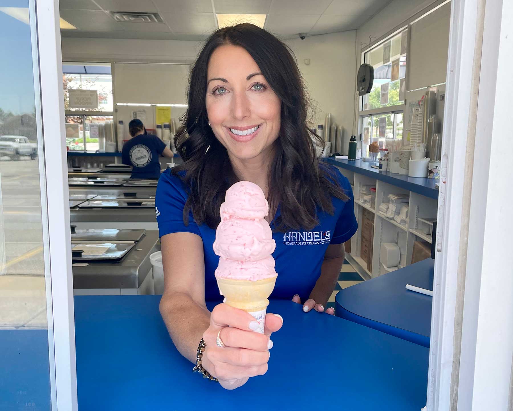 Handel's Ice Cream franchisee Leigh Jaffer serving a strawberry ice cream cone